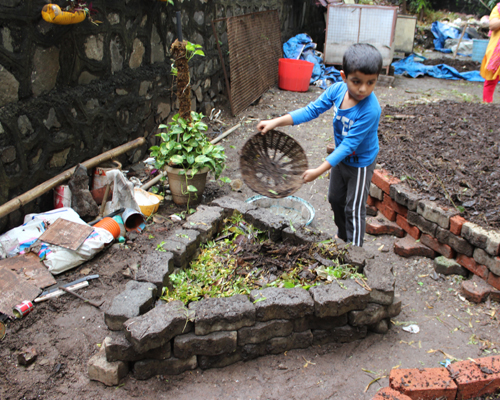 Children work on similar smaller pits that are gardens-in-the-making